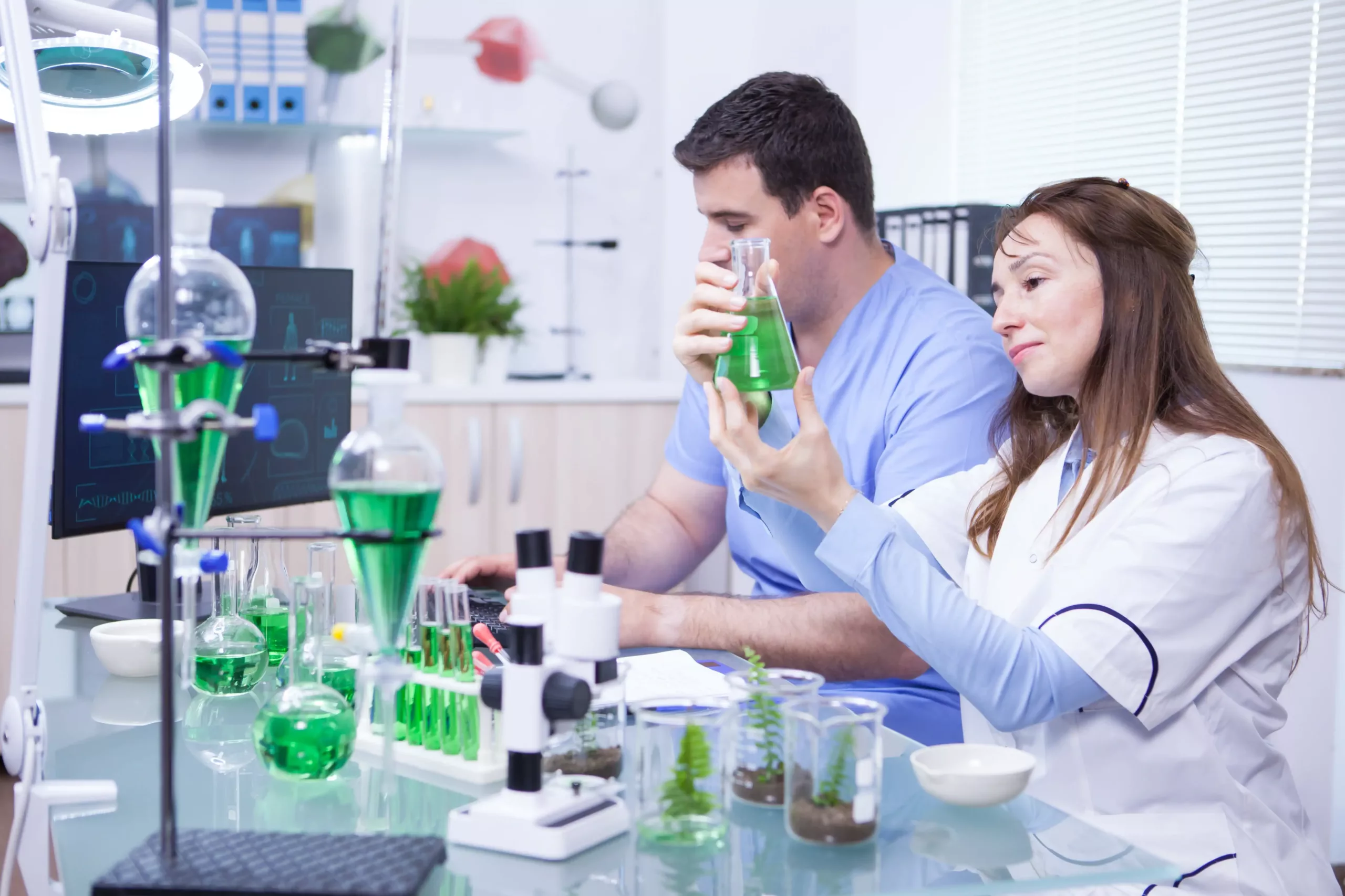 middle-age-woman-with-her-assistant-working-research-lab-microbiology-test-tubes