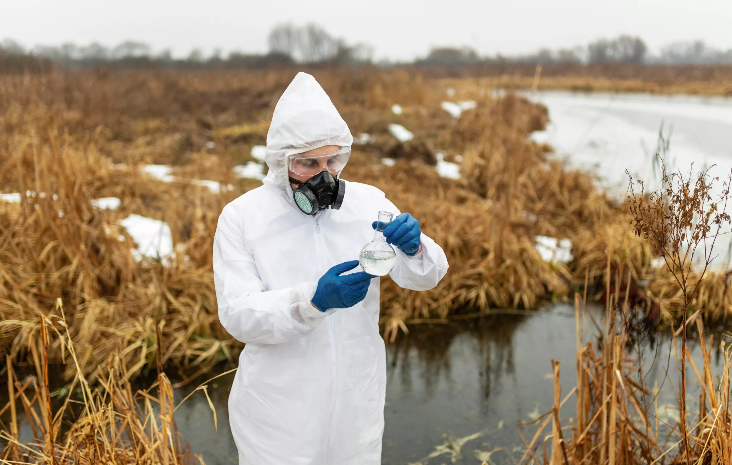 scientist wearing protective suit and doing wastewater testing